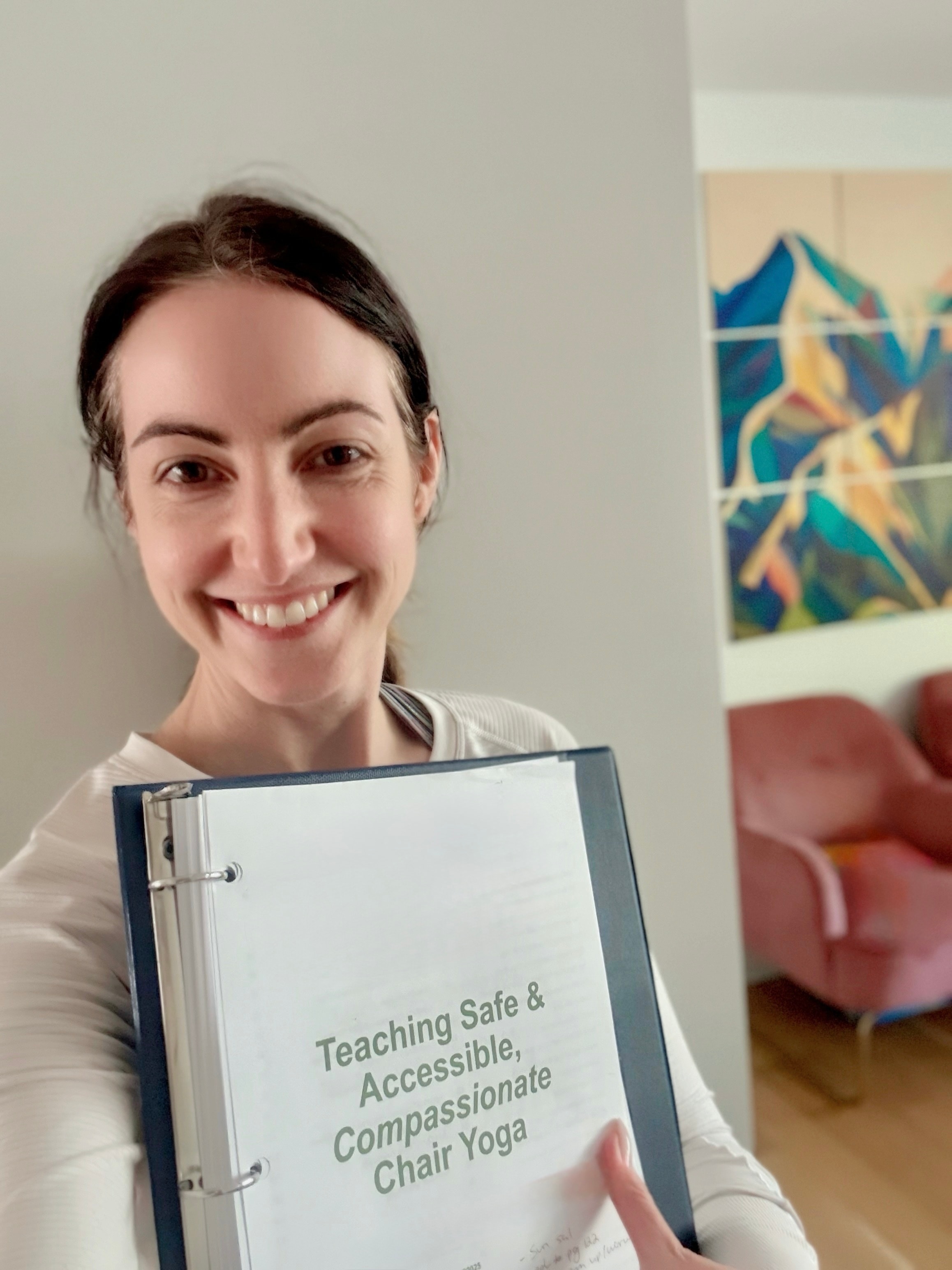 Sharla holding a Chair Yoga teaching binder